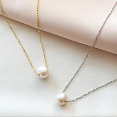 Single white freshwater Pearl necklace in silver and gold. Cheap White Pearl Pendant Charm Necklace, Single Pearl Necklace Tiffany & Co., Classic Pearl White Necklace With Clavicle Chain, Classic Akoya Pearl Clavicle Chain Necklace, White Pearl Necklace With Delicate Chain For Formal Occasions, White Clavicle Chain Bridal Necklace For Formal Occasions, Formal White Bridal Necklace With Clavicle Chain, Classic Round Pearl Necklace With Clavicle Chain, White Pearl Necklace With Clavicle Chain As Gift