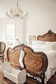 a large wooden bed sitting on top of a hard wood floor next to a window