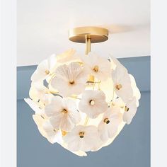 a ceiling light with white flowers hanging from it