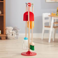 two brooms and a mop on a wooden floor in a child's room