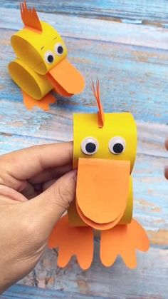 someone is holding up some paper cut outs to make a bird craft with googly eyes