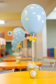 a blue balloon sitting on top of a yellow table