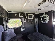 a living room with black walls and pictures on the wall