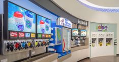 the inside of a store filled with vending machines and soda machines on display in front of them