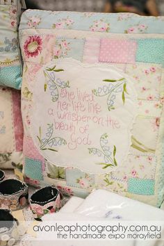 a close up of a pillow on a table with other pillows and items around it