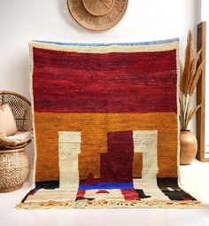 a colorful rug is on the floor next to a wicker basket and potted plant