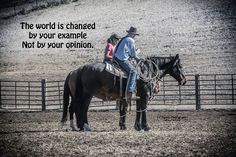 a man riding on the back of a black horse in an arena next to a fence