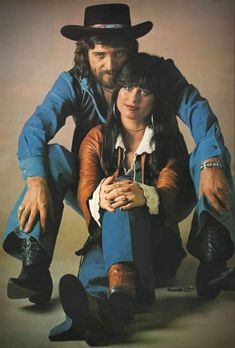 the man and woman are posing for a photo in cowboy hats with their arms around each other