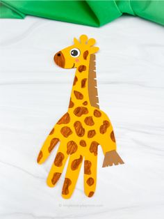 a paper cut out of a giraffe sitting on top of a bed