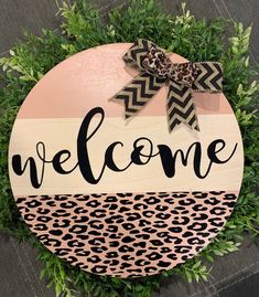 a welcome sign with a cheetah print on it and a bow at the top