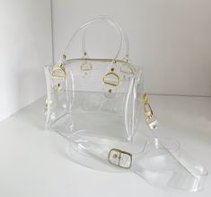 "Introducing our Clear Boxy Crossbody Handbag, the ultimate accessory for sporting events, concerts, and airport security. This versatile bag is not only stylish but also meets all the necessary regulations for these occasions. It's the perfect gift for travelers who value both fashion and functionality. With its hip bag design and convenient top handle, this minimalist handbag is a must-have for any fashion-forward individual. Its clear construction adds a modern touch while allowing for easy visibility of your belongings. Don't miss out on this trendy and practical accessory that will elevate your style and make your life easier. Bid now and secure this Clear Boxy Crossbody Handbag for yourself or as a thoughtful gift! 20,5 x 13,5 x 12 cm/ 8 x 5,31 x 4,72 inches strap max 130 cm/ 51 inch Minimalist Handbag, Gift For Traveler, Clear Handbags, Clear Purses, Jelly Bag, Airport Security, Cookie Bags, Transparent Bag, Wedding Cookies