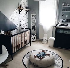 a baby is laying on a bean bag in the middle of a room with black and white decor