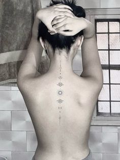 the back of a woman's neck with tattoos on it