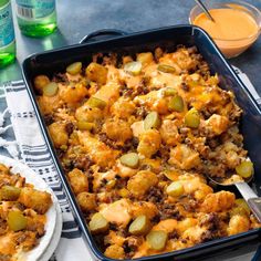 a casserole dish with meat, cheese and pickles in it on a table