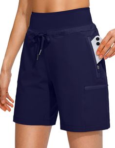 a woman in blue shorts holding an electronic device