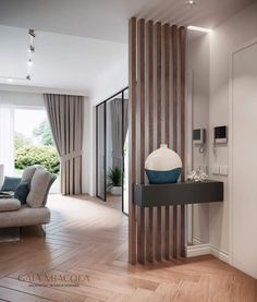 a modern living room with wood flooring and white walls, along with large windows