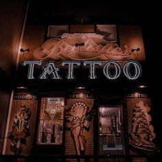 the front of a tattoo shop lit up at night