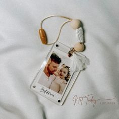 a couple's photo is attached to a keychain on a white sheet