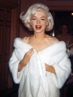 marilyn monroe wearing a white fur coat and posing for the camera