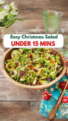 a wooden bowl filled with salad on top of a blue and white table cloth next to a