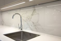 a kitchen with marble counter tops and stainless steel sink faucet in the middle