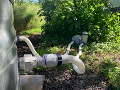 a couple of pipes that are on the ground in front of some bushes and trees