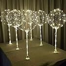 four lighted wine glasses sitting on top of a table next to each other in front of a curtain