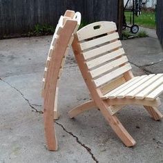 a wooden lawn chair sitting on top of a cement floor next to a garage door