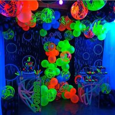 balloons and streamers are hanging from the ceiling in this party room decorated with neon colors