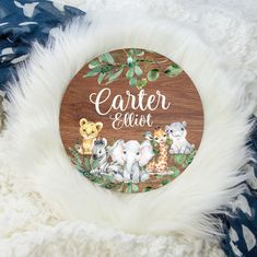 a wooden sign that says center elot with animals and leaves around it on a white fur rug