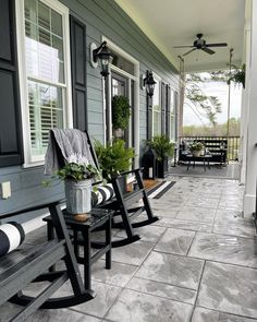 two black rocking chairs sitting on the front porch