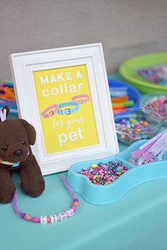 a teddy bear sitting on top of a table next to a sign that says make a collar for your pet