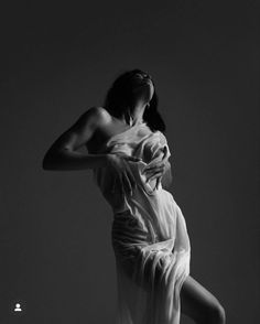 a woman in a white dress is dancing with her arms behind her head and back to the camera