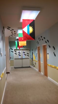 an empty hallway with flags hanging from the ceiling