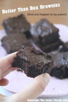 a person holding up a chocolate brownie on a plate with the words, better than box brownies that just happen to be pale