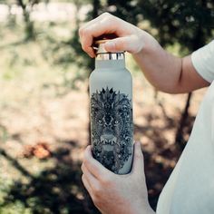 a person is holding a water bottle in their left hand and the other hand holds it