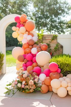 an arch made out of balloons and flowers