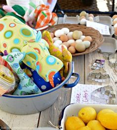 a bucket full of lemons sitting on top of a wooden table next to eggs