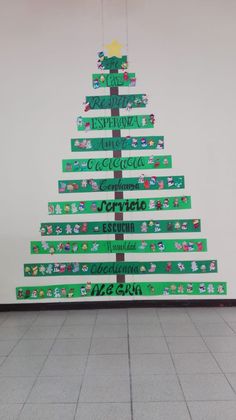 a christmas tree made out of green ribbon with writing on the bottom and below it