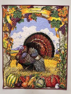 a quilted wall hanging with a turkey and pumpkins in the grass next to it