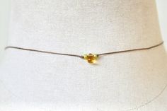 Simple and dainty.Features a glass citrine teardrop,tiny green glass beads,brown nylon cord.Necklace measures 14” with a 2” extension.Necklace finishes with a lobster claw closure.If you would like this longer or shorter just leave a note to seller at checkout. Dainty Necklace With Delicate Chain For Festival, Adjustable Delicate Chain Choker, Dainty Yellow Jewelry With Tiny Beads, Elegant Yellow Jewelry With Tiny Beads, Yellow Tiny Beads Choker As Gift, Yellow Tiny Beads Choker For Gift, Dainty Adjustable Festival Choker, Minimalist Adjustable Tiny Beads Choker, Handmade Delicate Adjustable Choker