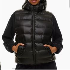 This Is A Lightweight Hooded Puffer Vest That Packs Down Into Its Own Interior Pocket. Wear It On Its Own Or As A Base Layer Under Coats And Jackets When The Temperature Really Drops. It’s Constructed With Lite Shine Water-Repellent And Wind-Resistant Fabric With A Pearlescent Finish And A Soft Feel. Materials & Care Content: 100% Nylon; Fill: 90% Goose Down, 10% Goose Feathers Care: Hand Wash Imported Fit: Classic Follows Your Contours With A Little Room Length: Classic Intended To Hit Between Hooded Puffer Vest, The Super Puff, Boss Lady Gifts, Aritzia Jacket, Puff Vest, Puffy Vest, Goose Feathers, Water Repellent Fabric, Coats And Jackets