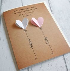 two paper hearts are attached to a card