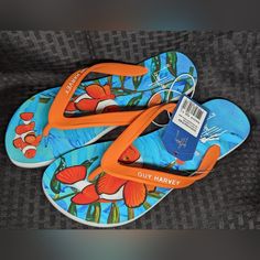 From Land To Sea, Start Your Next Adventure With The Women's Cayman Flip Flop. These Eye Catching Sandals Feature High Quality Molded Rubber, Embossed Branding On The Strap And A Wave Patterned Blown Rubber Outsole. Representation Of The Artist Can Be Found On The Cushioned Footbed With A Full Color Digital Print Of Guy Harvey's Artwork. Orange Synthetic Flip Flops, Orange Flat Flip Flops Casual Style, Casual Orange Flat Flip Flops, Orange Casual Flat Flip Flops, Orange Flat Flip Flops For Vacation, Orange Slip-on Flip Flops For Beach, Orange Round Toe Flip Flops For Vacation, Casual Orange Flip Flops For Beach, Casual Orange Flip Flops For The Beach