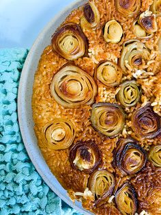 a pan filled with cooked artichokes on top of a blue table cloth