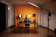 a man sitting at a desk in front of a laptop computer on a tripod