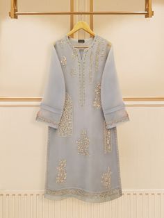 grey embroidered organza straight shirt crafted with utmost care and attention to detail. The shirt features intricate embroidery on the front and sleeves, adding a touch of timeless charm. Paired with a matching pant Length: 46" Pants Fabric: Raw Silk Gray Resham Embroidery Kurta For Wedding, Elegant Gray Kurta With Resham Embroidery, Elegant Gray Designer Wear Sets, Elegant Gray Sets For Eid, Elegant Gray Kurta For Eid, Gray Salwar Kameez For Eid, Gray Embroidered Kurta For Eid, Embroidered Gray Kurta For Eid, Agha Noor