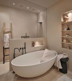 a large white bath tub sitting next to a walk in shower