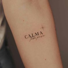 a woman's arm with a tattoo that reads calma and the word love is written in cursive font