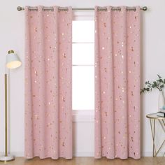 a pink curtain with gold speckles in front of a white wall and floor